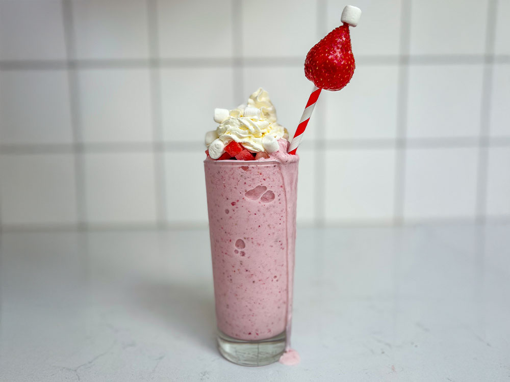 Santa's Strawberry Marshmallow frappe toppad med grädde och minimarshmallows.